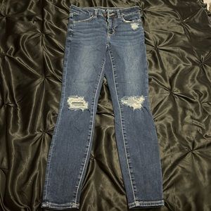 american eagle blue jeans with rips at knees.